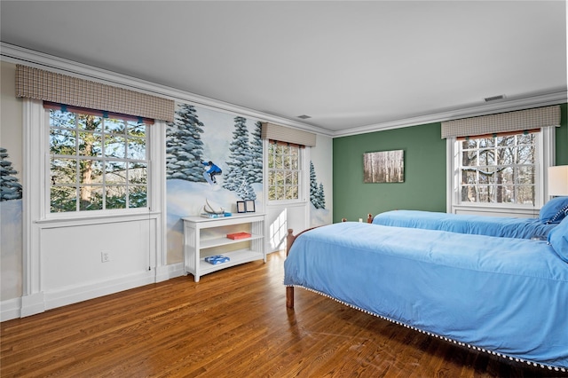 bedroom featuring multiple windows, wood finished floors, and crown molding