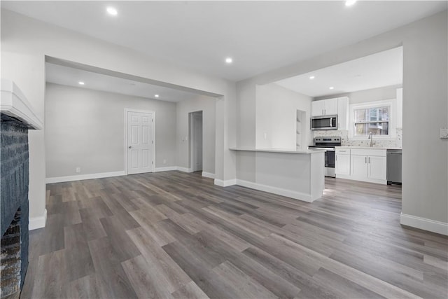 unfurnished living room with light wood-type flooring and sink