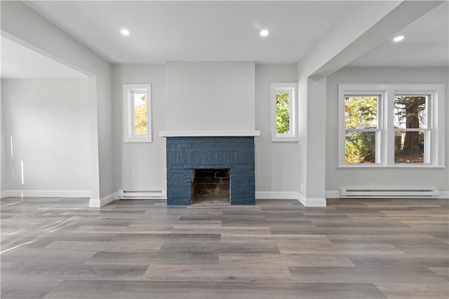 unfurnished living room with light wood-type flooring, a fireplace, and a baseboard heating unit