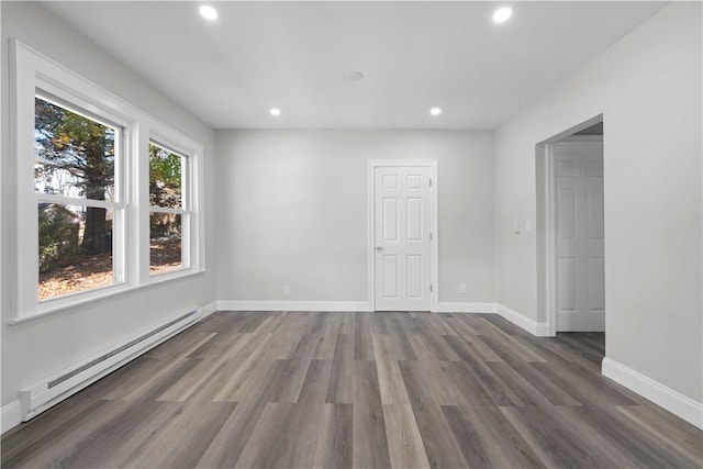 empty room featuring dark hardwood / wood-style flooring and a baseboard radiator