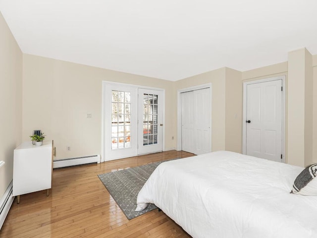 bedroom with access to exterior, a baseboard radiator, and hardwood / wood-style flooring