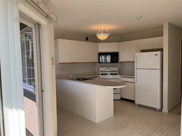 kitchen with white appliances, white cabinets, sink, decorative light fixtures, and kitchen peninsula