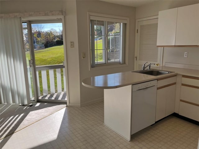 kitchen featuring white cabinets, dishwasher, kitchen peninsula, and sink