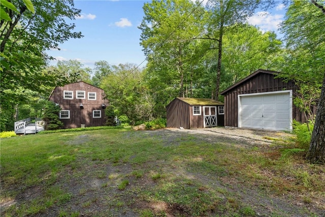 view of yard featuring a garage and a storage shed