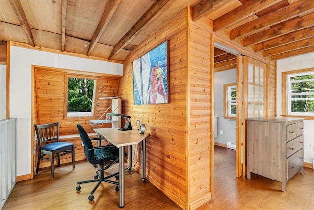 home office with beam ceiling, wooden walls, baseboard heating, and light wood-type flooring