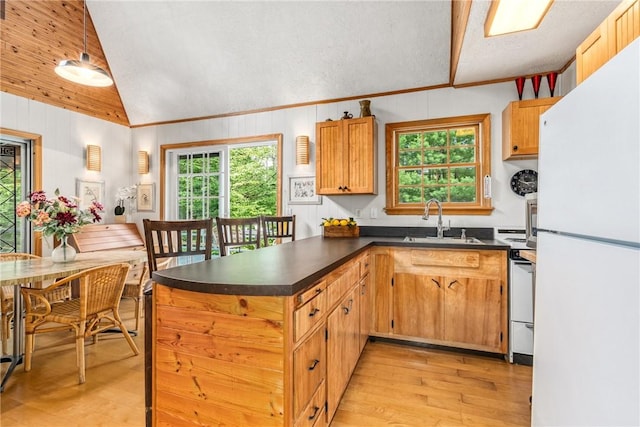 kitchen with stove, sink, white refrigerator, light hardwood / wood-style flooring, and lofted ceiling