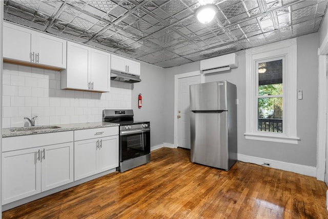 kitchen with white cabinetry, sink, stainless steel appliances, dark hardwood / wood-style floors, and a wall mounted AC