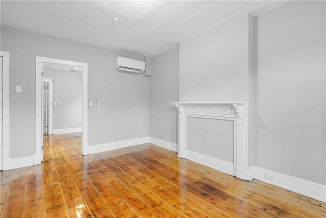 unfurnished room featuring wood-type flooring and a wall unit AC