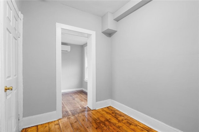 spacious closet featuring hardwood / wood-style floors and an AC wall unit