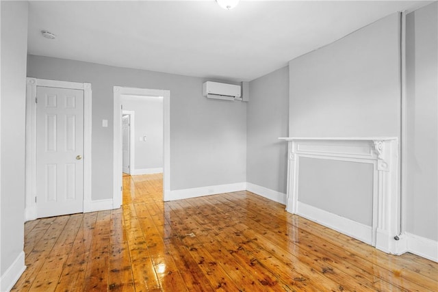 spare room featuring an AC wall unit and wood-type flooring