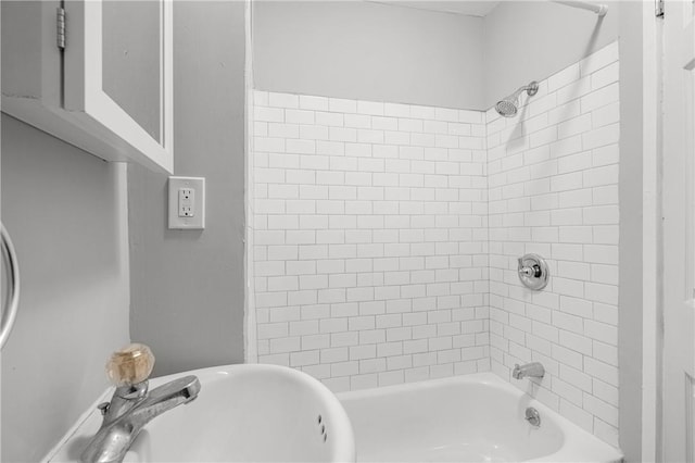 bathroom with tiled shower / bath combo and sink