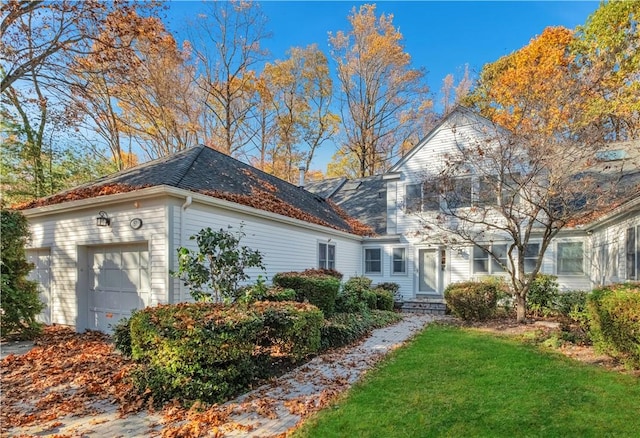 view of side of home with a garage and a lawn