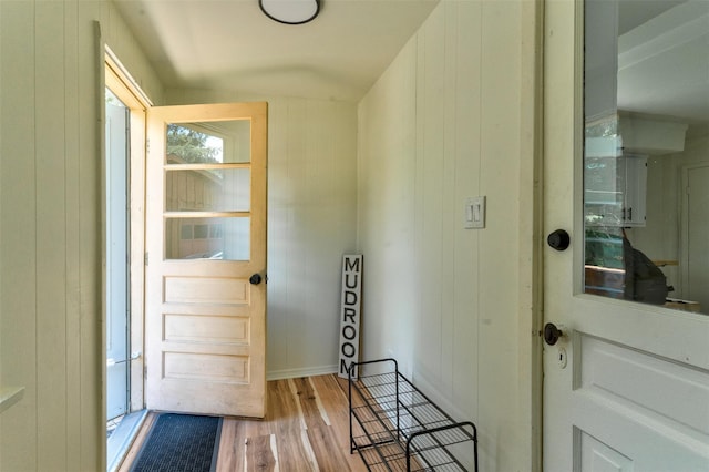 doorway featuring wood walls and light wood-type flooring