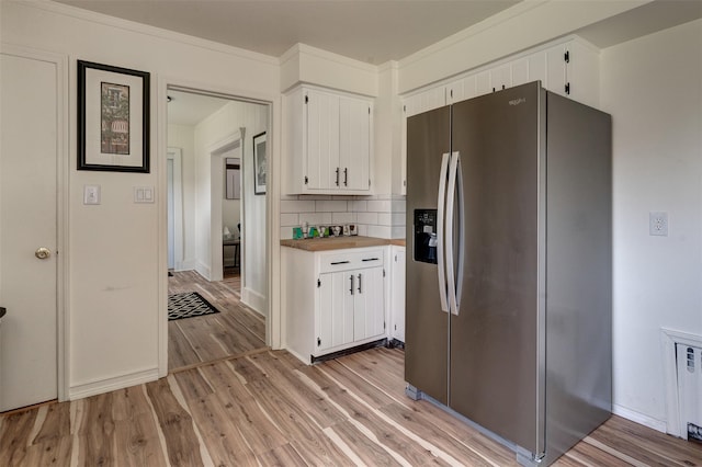 kitchen with white cabinets, stainless steel fridge with ice dispenser, and light hardwood / wood-style flooring