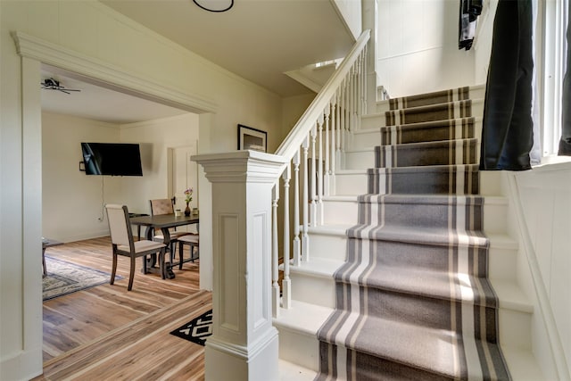 stairway featuring ornamental molding and hardwood / wood-style flooring