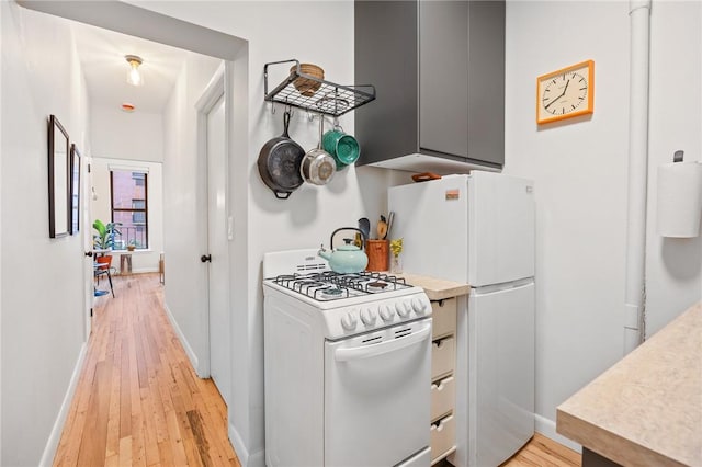 kitchen with white appliances, baseboards, light wood-style floors, light countertops, and gray cabinets