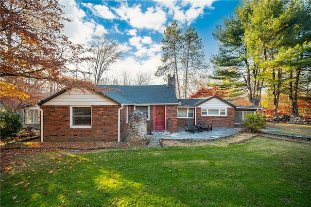 back of property with a patio area and a yard