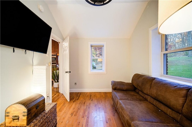 living room featuring lofted ceiling and light hardwood / wood-style flooring