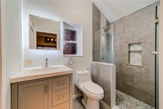 bathroom with vanity, toilet, tiled shower, and vaulted ceiling