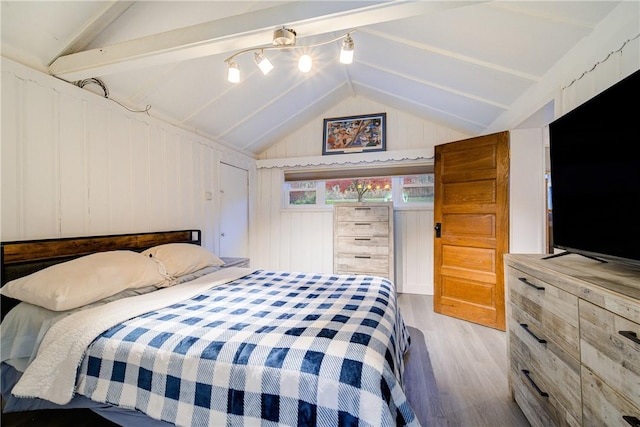 bedroom featuring lofted ceiling with beams, light hardwood / wood-style floors, and wooden walls