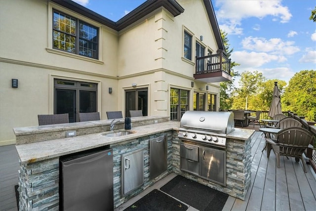 view of patio featuring sink, a balcony, grilling area, and exterior kitchen