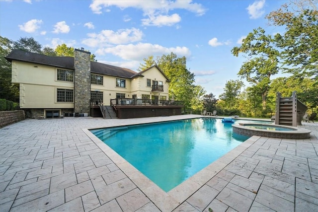 view of pool with a patio area and an in ground hot tub