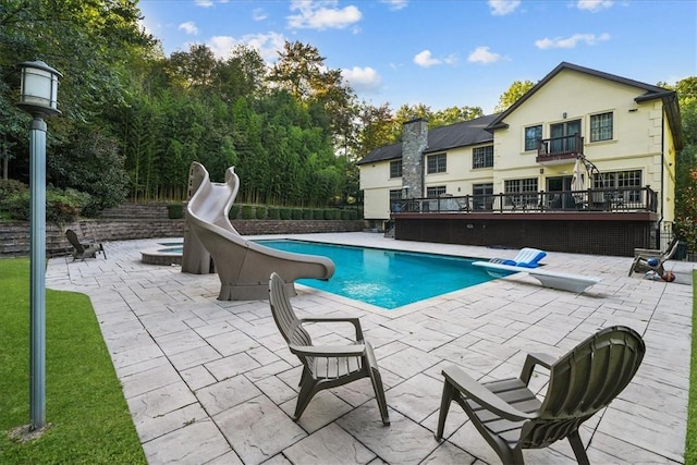 view of swimming pool with a patio area and a water slide