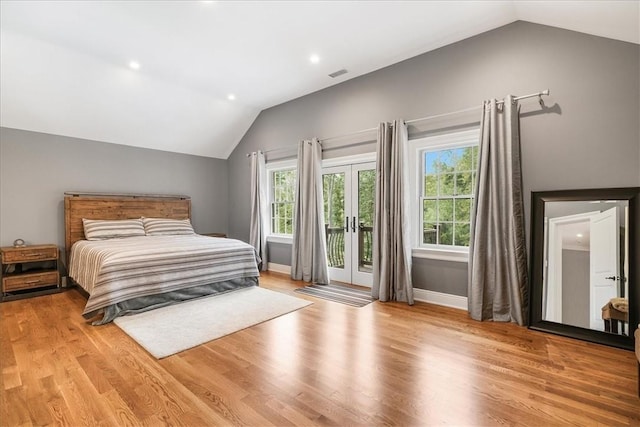 bedroom featuring access to exterior, light hardwood / wood-style flooring, and multiple windows