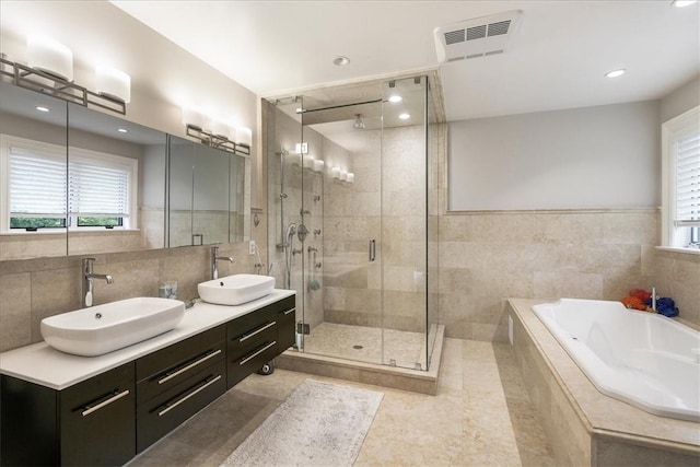 bathroom featuring tile patterned flooring, vanity, separate shower and tub, and tile walls