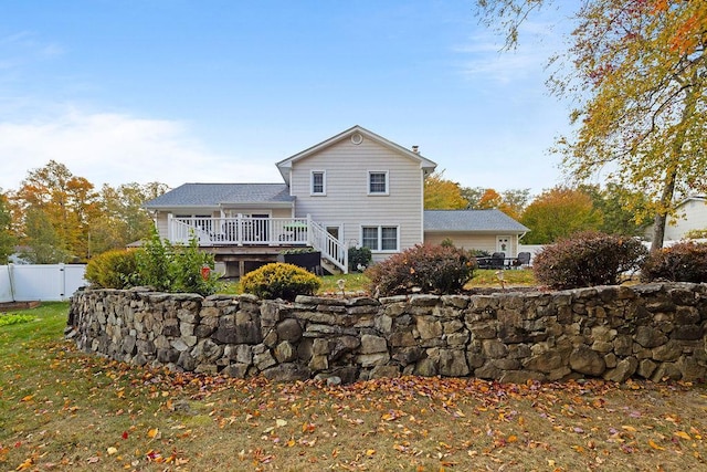 back of house featuring fence and a wooden deck