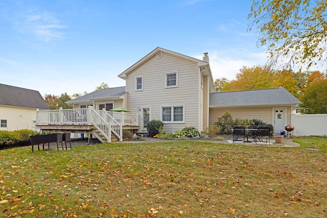 back of property with fence, a wooden deck, a yard, a chimney, and a patio area