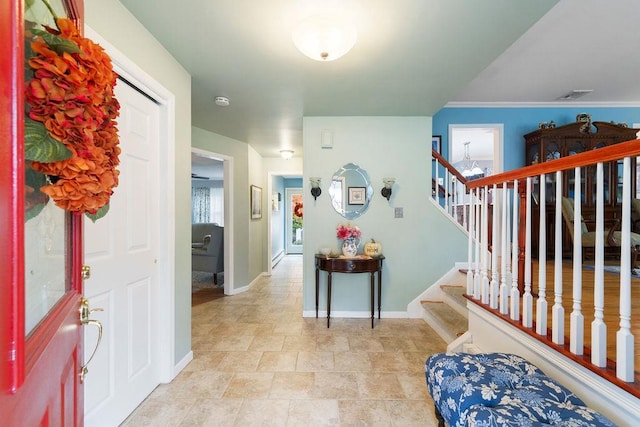 foyer featuring stairs, baseboards, and visible vents