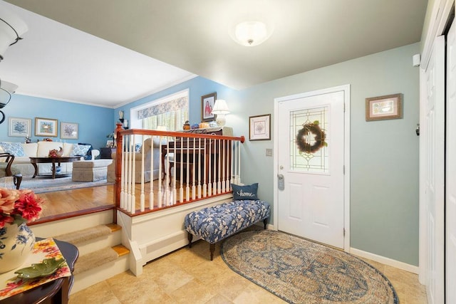 entrance foyer with crown molding and baseboards