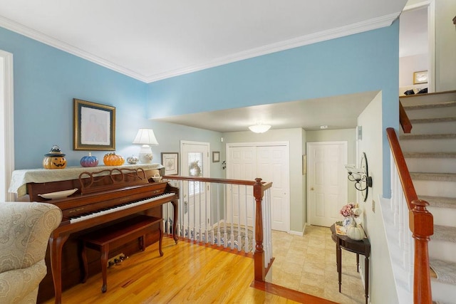 living area with stairs, light wood-type flooring, baseboards, and crown molding