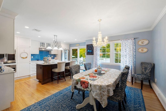 dining space with visible vents, light wood-style flooring, and crown molding