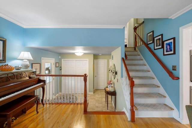 staircase featuring baseboards, wood finished floors, and crown molding