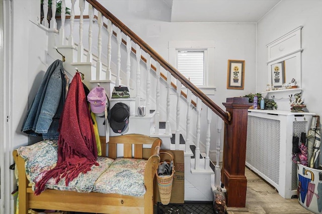 stairs featuring radiator and hardwood / wood-style floors