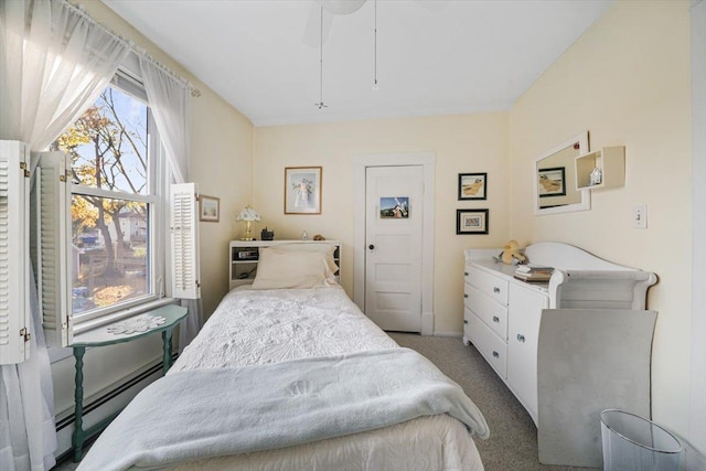 carpeted bedroom featuring baseboard heating and ceiling fan