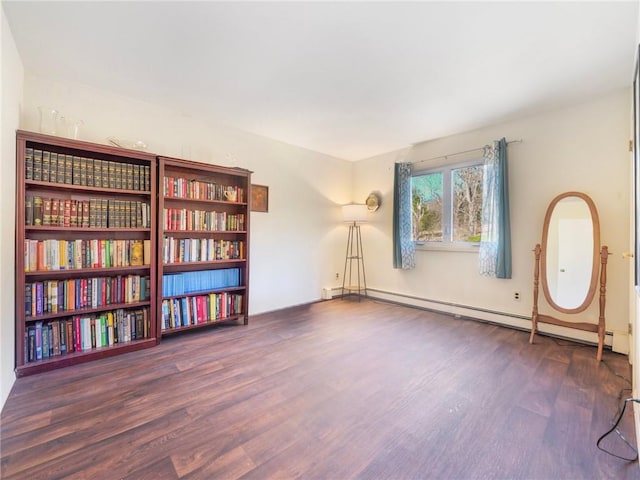 interior space featuring a baseboard heating unit and dark wood-type flooring