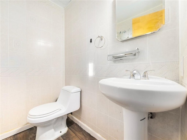 bathroom with hardwood / wood-style flooring and tile walls