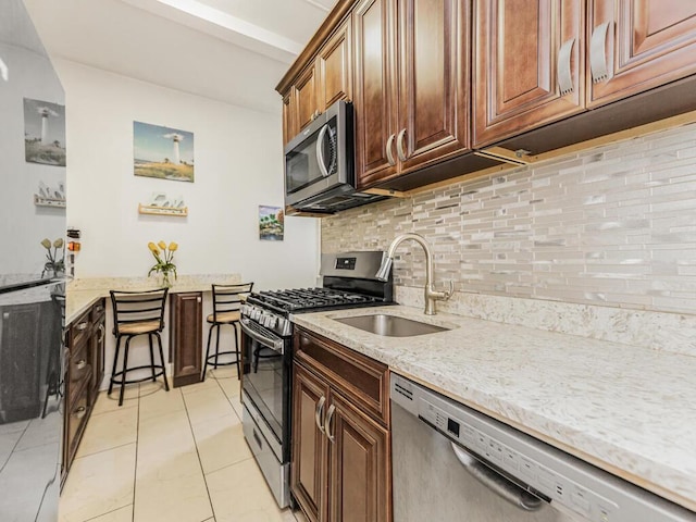 5601 Riverdale Ave Unit 1C, Bronx, NY 10471 - kitchen with appliances with stainless steel finishes, a sink, decorative backsplash, light stone countertops, and light tile patterned floors