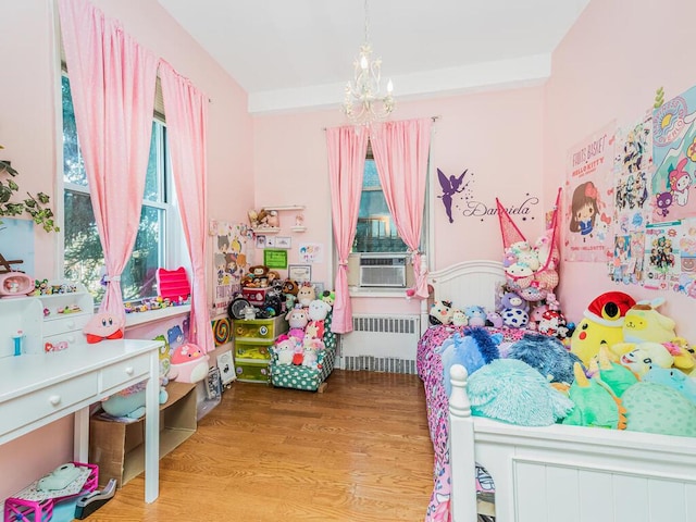 5601 Riverdale Ave Unit 1C, Bronx, NY 10471 - bedroom featuring radiator heating unit, a chandelier, cooling unit, and wood finished floors