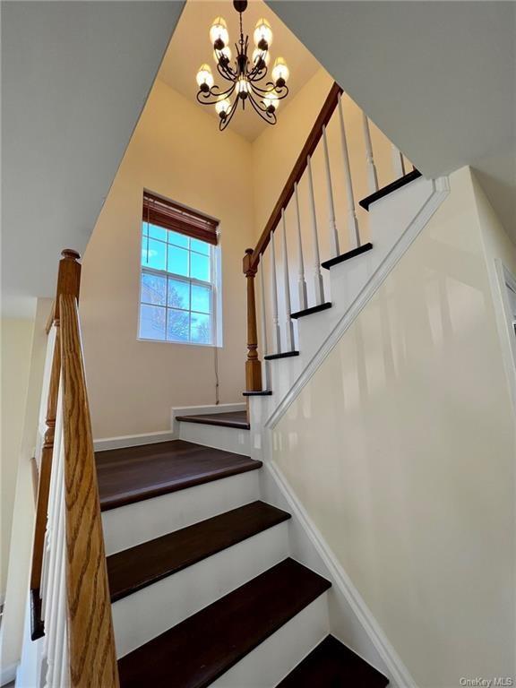 stairs with an inviting chandelier