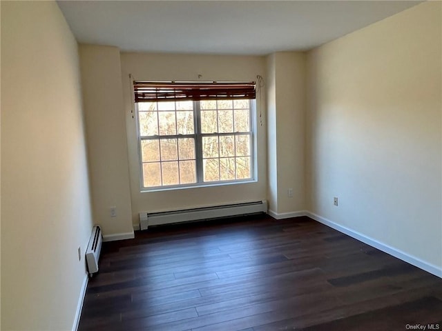 empty room with dark wood-type flooring and a baseboard heating unit