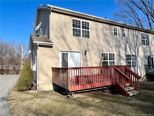 rear view of property with a yard and a wooden deck