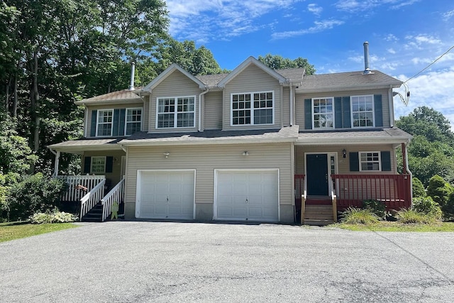 view of front of property featuring an attached garage, covered porch, and aphalt driveway