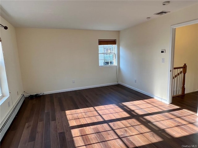 unfurnished room with dark wood-style flooring, a baseboard radiator, visible vents, and baseboards