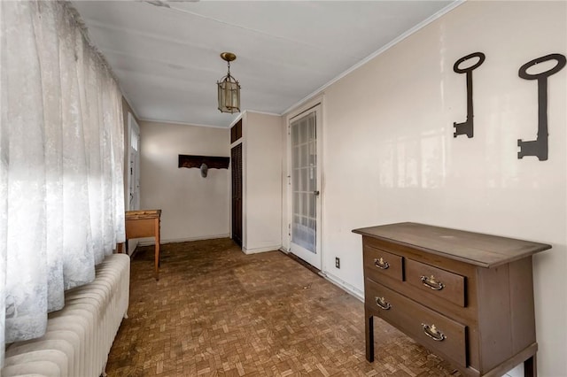 interior space featuring dark parquet flooring and ornamental molding