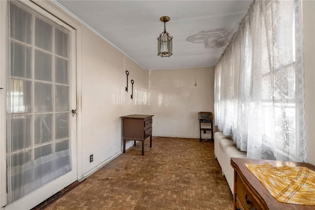 interior space with dark parquet flooring and crown molding