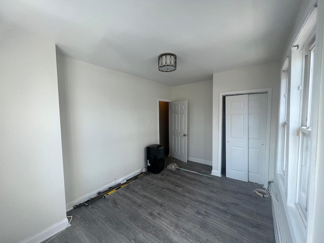 unfurnished bedroom featuring dark wood-type flooring and a closet